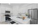 Modern kitchen boasts stainless steel appliances, white cabinetry, and a center island with seating at 17 Cypress Run, Haines City, FL 33844