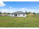 The back exterior features a spacious yard, a covered patio, and a pristine white exterior at 17315 Sw 26Th Terrace Rd, Ocala, FL 34473