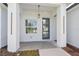 Inviting front porch featuring a modern blue door, pendant lighting, and bright natural light from the adjacent window at 17315 Sw 26Th Terrace Rd, Ocala, FL 34473