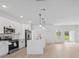 Open concept kitchen features stainless appliances, white cabinets, and a center island with pendant lighting at 17315 Sw 26Th Terrace Rd, Ocala, FL 34473