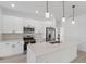 Modern kitchen with white cabinets, stainless steel appliances, and a large island with a sink and bar seating at 17315 Sw 26Th Terrace Rd, Ocala, FL 34473