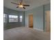 Light-filled bedroom with neutral carpet, light blue walls, and ceiling fan with light at 17322 Chateau Pine Way, Clermont, FL 34711