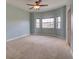 Bright bedroom featuring neutral carpet, light blue walls, and large window for natural light at 17322 Chateau Pine Way, Clermont, FL 34711