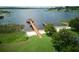 Aerial view of the lakefront with a long wooden dock, a gazebo, and lush greenery at 17322 Chateau Pine Way, Clermont, FL 34711