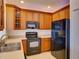 Well-lit kitchen featuring wood cabinets, black appliances, and a stainless steel sink at 17322 Chateau Pine Way, Clermont, FL 34711