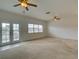 Bright living room features carpeting, ceiling fans, and a sliding glass door to an outdoor balcony at 17322 Chateau Pine Way, Clermont, FL 34711
