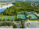 An aerial view highlights the community's multiple tennis and basketball courts surrounded by lush landscaping and waterways at 2021 Sweet Birch Ln, Orlando, FL 32828