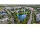 Aerial view of a community featuring a pond, green spaces, roads, and townhomes at 2021 Sweet Birch Ln, Orlando, FL 32828