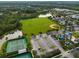 An aerial view shows tennis courts, sports fields, playground, and parking area within a well-maintained community setting at 2021 Sweet Birch Ln, Orlando, FL 32828