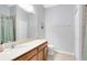 Bathroom featuring a tiled shower, a framed mirror, a single sink vanity with storage, and a toilet at 2021 Sweet Birch Ln, Orlando, FL 32828