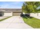 A row of townhomes featuring garages, driveways, lawns, and landscaping at 2021 Sweet Birch Ln, Orlando, FL 32828