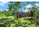 Manicured backyard with lush greenery and a screened patio with outdoor kitchen at 209 7Th S St, Haines City, FL 33844