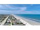 Aerial view of a beach, ocean, and coastal community under a bright blue sky at 2121 Hill St # 7B, New Smyrna Beach, FL 32169