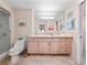 Bright bathroom featuring a glass shower, marble countertop, and a large mirror at 2121 Hill St # 7B, New Smyrna Beach, FL 32169