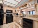 Bright kitchen boasts black appliances, tan countertops, and light cabinets open to another room at 2121 Hill St # 7B, New Smyrna Beach, FL 32169