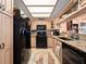 Bright kitchen features black appliances, tan countertops, unique flooring, and light-colored cabinets at 2121 Hill St # 7B, New Smyrna Beach, FL 32169