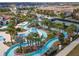 A community lazy river winds through lush landscaping and palm trees in this aerial image at 2121 Morocco Way, Kissimmee, FL 34747
