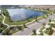 Aerial view of a community lake with walking trails, lush landscaping, and a central fountain feature at 2121 Morocco Way, Kissimmee, FL 34747