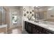 Elegant Primary bathroom with double sinks, granite countertops, modern fixtures, and a walk-in shower, plus access to the pool at 2121 Morocco Way, Kissimmee, FL 34747
