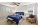 Stylish bedroom featuring a king bed with blue bedding, a patterned accent wall, and soft natural light at 2121 Morocco Way, Kissimmee, FL 34747