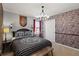 Bedroom features a unique stone-wall wallpaper design and circular chandelier for a rustic, yet modern feel at 2121 Morocco Way, Kissimmee, FL 34747