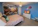 Bright bedroom featuring a castle mural, a crystal chandelier, and cheerful blue walls at 2121 Morocco Way, Kissimmee, FL 34747