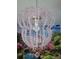 A pink chandelier with crystal accents hangs above a vibrant fairytale backdrop at 2121 Morocco Way, Kissimmee, FL 34747