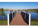 Community dock overlooking a tranquil lake with beautiful homes in the distance on a clear sunny day at 2121 Morocco Way, Kissimmee, FL 34747