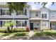 Charming townhome featuring a well-manicured front yard with lush landscaping and stone accents at 2211 J Lawson Blvd, Orlando, FL 32824