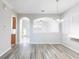 Bright, open-concept living area with arched openings and wood flooring at 2211 J Lawson Blvd, Orlando, FL 32824