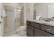Bathroom with a glass-enclosed shower, granite counters, dark cabinetry, and neutral tile at 2438 Dubai St, Kissimmee, FL 34747