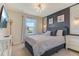 Bright bedroom featuring a bed with grey linens, a dark accent wall, and modern lighting fixtures at 2438 Dubai St, Kissimmee, FL 34747