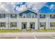 Charming two-story townhome featuring blue and gray siding, a well-manicured lawn, and inviting front entrances at 2438 Dubai St, Kissimmee, FL 34747