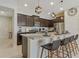 Bright kitchen featuring an island with bar seating, stainless steel appliances, and dark cabinets at 2438 Dubai St, Kissimmee, FL 34747