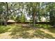 Beautifully landscaped backyard with picnic bench, mature trees, and a serene atmosphere at 26 Canter Club Ct, Debary, FL 32713