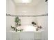 Relaxing white tiled bathroom with a bathtub and plants at 26 Canter Club Ct, Debary, FL 32713