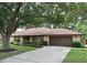 Charming brick home with a well-manicured lawn, mature trees, and a two-car garage at 26 Canter Club Ct, Debary, FL 32713