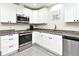 Modern kitchen with stainless steel appliances, granite countertops, and stylish white cabinetry at 26 Canter Club Ct, Debary, FL 32713