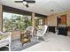 Relaxing screened porch with outdoor grill, wicker furniture, and a charming backyard view at 26 Canter Club Ct, Debary, FL 32713