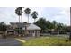Community entrance featuring a guard house, mature palm trees, and well maintained landscaping at 2622 Clarinet Dr, Orlando, FL 32837