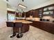 Open-concept kitchen with dark wood cabinetry, stainless steel appliances, granite counters and a central island at 2622 Clarinet Dr, Orlando, FL 32837