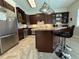 Bright eat-in kitchen with stainless appliances, dark cabinetry, tile backsplash, and counter seating at the island at 2622 Clarinet Dr, Orlando, FL 32837