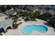 An aerial view of a community pool with a hot tub, lounge chairs, a fountain, palm trees and mature landscaping at 2622 Clarinet Dr, Orlando, FL 32837