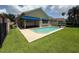 Backyard oasis featuring a private pool, artificial turf, and a covered patio at 2622 Clarinet Dr, Orlando, FL 32837