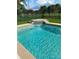 Beautiful backyard pool with small waterfall feature and views of the lush green surroundings at 2622 Clarinet Dr, Orlando, FL 32837
