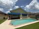 Beautiful pool with turquoise water, adjacent to home featuring blue awnings and a patio at 2622 Clarinet Dr, Orlando, FL 32837