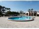 Community pool with palm trees, lounge chairs, umbrellas, and building at 2622 Clarinet Dr, Orlando, FL 32837
