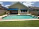Private backyard swimming pool with manicured artificial turf and a covered porch at 2622 Clarinet Dr, Orlando, FL 32837