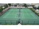 Aerial view of well-maintained, fenced-in tennis courts, and mature landscaping surrounding the courts at 2622 Clarinet Dr, Orlando, FL 32837