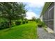 Lush green backyard with mature trees and a glimpse of the screened-in lanai at 3142 Dark Sky Dr, Harmony, FL 34773